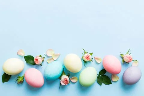 Happy Easter. Easter eggs on colored table with yellow roses. Natural dyed co 写真素材