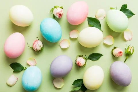 Happy Easter. Easter eggs on colored table with yellow roses. Natural dyed co 库存照片