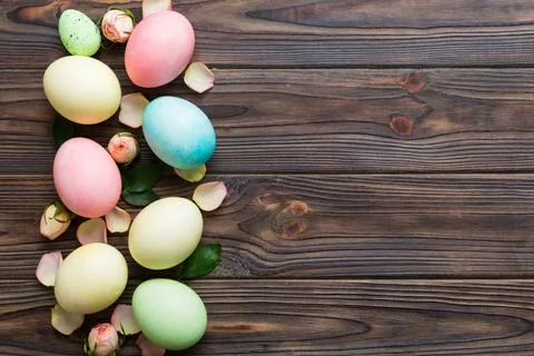 Happy Easter. Easter eggs on colored table with yellow roses. Natural dyed co 스톡 사진