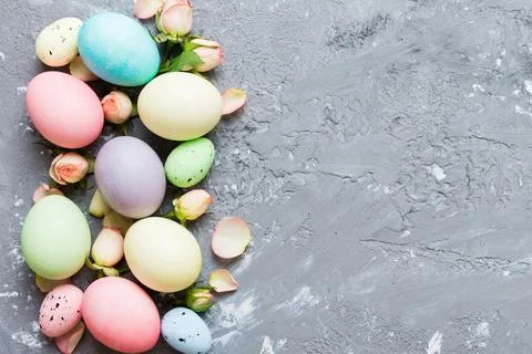 Happy Easter. Easter eggs on colored table with yellow roses. Natural dyed co 库存照片