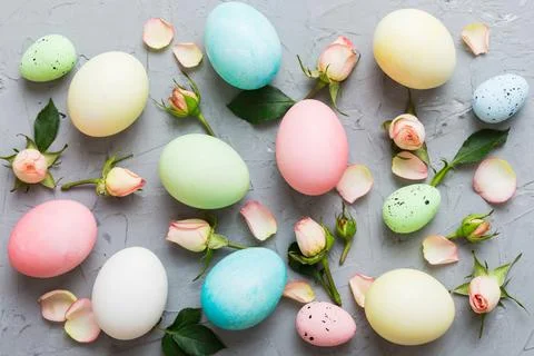 Happy Easter. Easter eggs on colored table with yellow roses. Natural dyed co 스톡 사진
