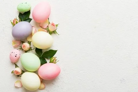 Happy Easter. Easter eggs on colored table with yellow roses. Natural dyed co 库存照片
