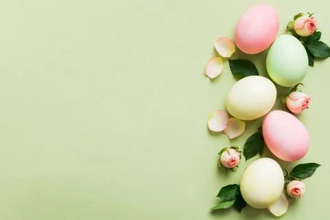 Happy Easter. Easter eggs on colored table with yellow roses. Natural dyed co Stock Photos