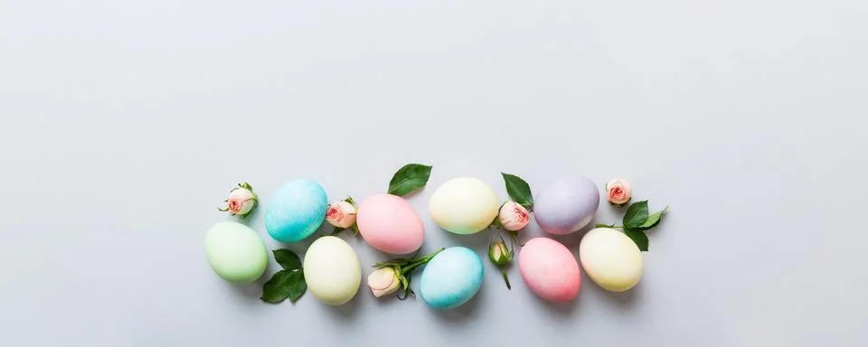 Happy Easter. Easter eggs on colored table with yellow roses. Natural dyed co Stock Photos
