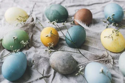 Happy Easter! Easter eggs on rustic linen napkin with tender flowers. Rusti.. Stock Photos