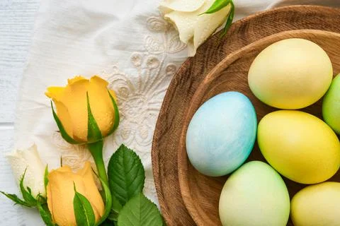 Happy Easter. Easter eggs on rustic table with white and yellow roses. Natu.. Stock Photos
