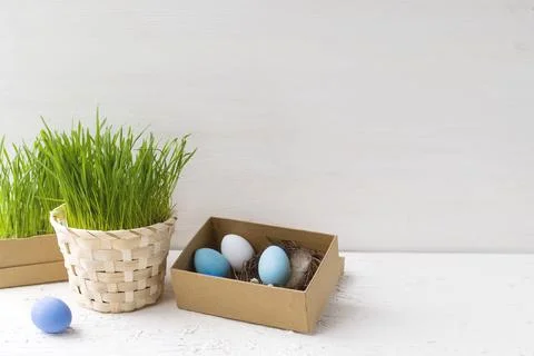 Happy Easter. Easter eggs in a small nest next to fresh spring grass in a pot on 写真素材