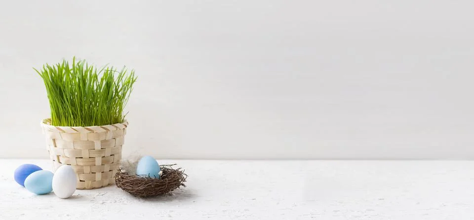 Happy Easter. Easter eggs in a small nest next to fresh spring grass in a pot on 写真素材