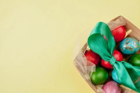 Happy Easter eggs yellow background. Golden shine decorated eggs in basket, f Stock Photos