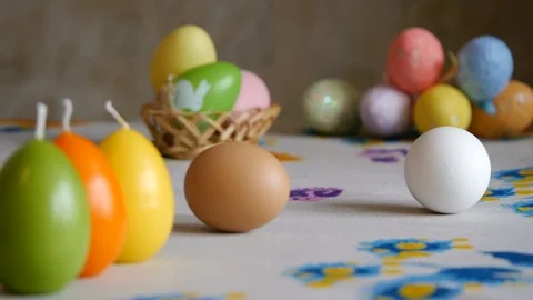 Happy Easter. female hands take off the table two easter eggs. colorful candles Stock Footage 106147890