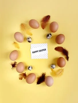 Happy Easter flat lay composition. Easter eggs decorated feathers on backgrou Stock Photos