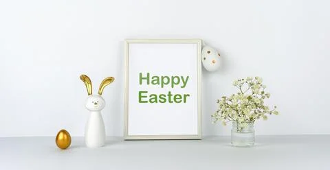 Happy Easter. Frame and flowers on background of white table and wall. Eggs a Stock Photos