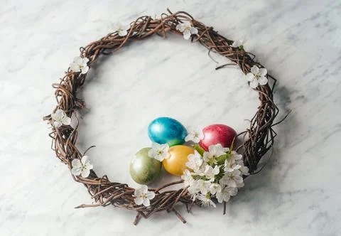 Happy Easter greeting card with Easter wreath, dyed eggs and spring flowers Stock Photos