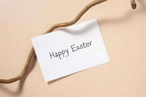 Happy Easter greeting card with tree branch on beige background. Stock Photos