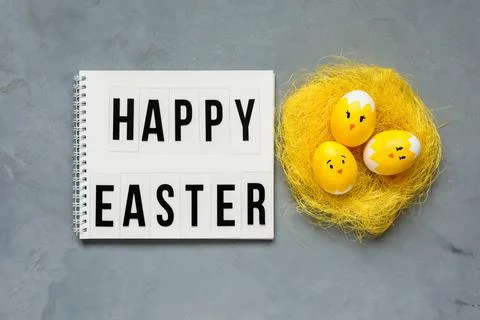 Happy Easter greeting, Easter eggs painted as chick laying on the yellow nest on Stock Photos