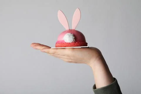 Happy Easter. Hand is holding creative desert with bunny ears. Isolated. Fotos Stock