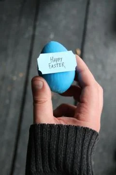 Happy easter. Hand holding an egg with tag Stock Photos