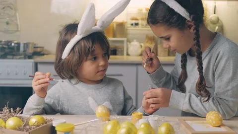 Happy Easter Holiday. Beautiful children paint and decorate an egg for a Stock Footage 148073698