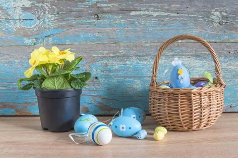 Happy Easter holiday composition; Wicker basket with easter eggs and yellow.. Stock Photos