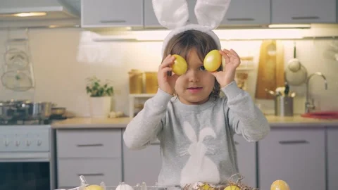 Happy Easter Holiday. Cute kid plays with colored eggs for a spring traditional Stock Footage 148039285