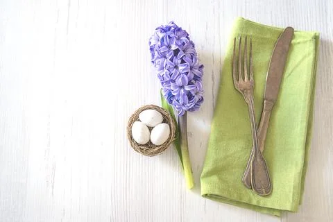 Happy Easter holiday place setting. Vintage fork and knife on green napkin,.. Stock Photos