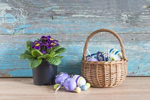 Happy easter holidays concept; Wicker basket with easter eggs and purple pr.. Stock Photos