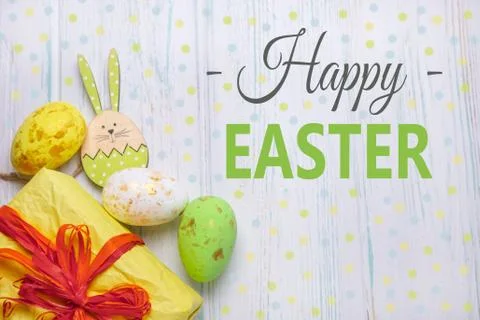 Happy easter. The inscription on the greeting Easter card with eggs, hares on Stock Photos