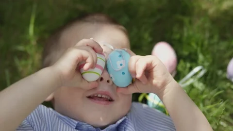 Happy easter kid portrait little child boy lying green grass put easter eggs Video stock 231293389