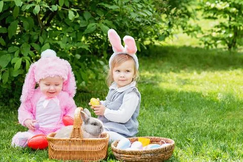 Happy Easter. Laughing child at Easter egg hunt with pet bunny. Stock Photos