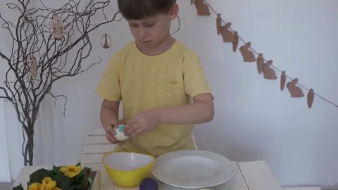 Happy Easter. Little boy peels the Easter egg Stock Footage 147950963