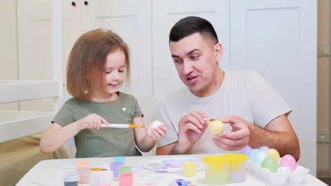 Happy easter. Little daughter and dad painted eggs at home. Daughter kisses Dad Stock Footage 170876889