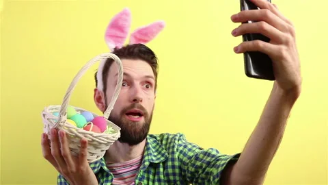 Happy easter  man in bunny ears headband using smartphone video call blogger Stock Footage 148226713