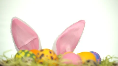 Happy Easter. A man with rabbit ears looks out from behind Easter eggs Stock Footage 124858185