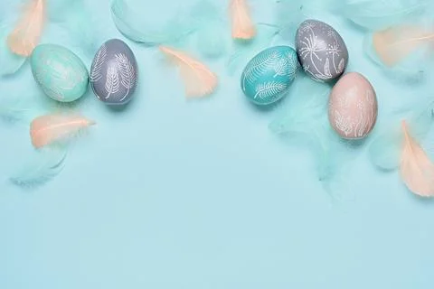 Happy easter minimal background. Easter eggs and feathers on blue pastel Stock Photos