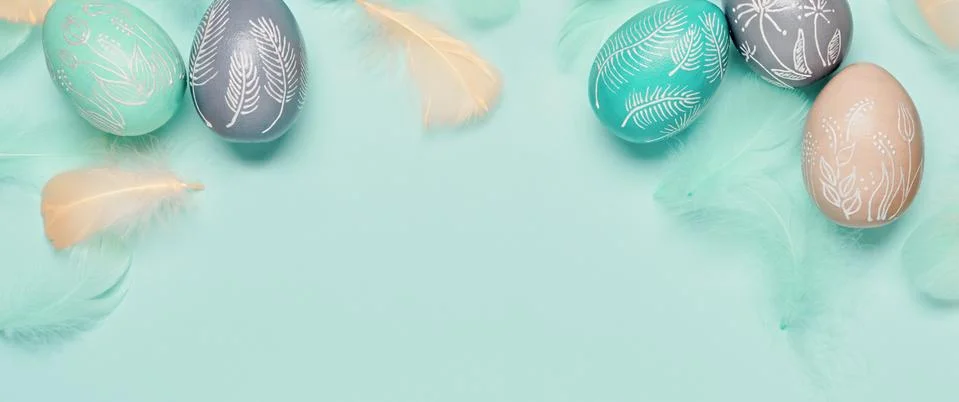 Happy easter minimal banner. Easter eggs and feathers on turquoise pastel Stock-Fotos