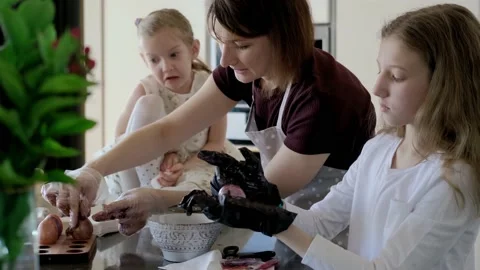 Happy Easter. Mom and two cute daughters paint eggs for the traditional spring Stock Footage 220079469