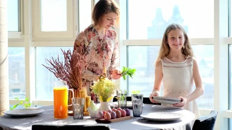 Happy Easter. Mom and two cute daughters paint eggs for the traditional spring Stock Footage 220079804