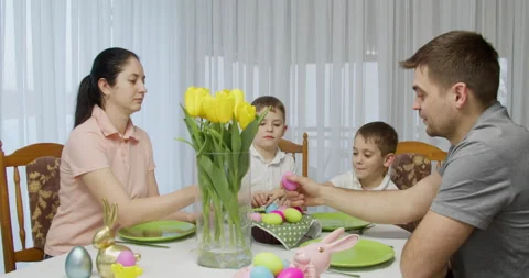 Happy Easter. mom, dad and kids having fun hitting holiday eggs Stock Footage 176527887