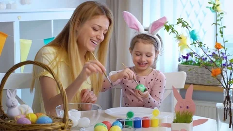 Happy Easter! Mother and her daughter with Bunny ears coloring Easter eggs Stock Footage 84845037