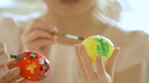 Happy Easter! Mother and her daughter with rabbit ears coloring Easter eggs Stock Footage 84847852