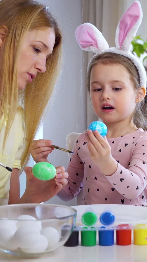 Happy Easter Mother and her little daughter coloring easter eggs Stock Footage 265176907