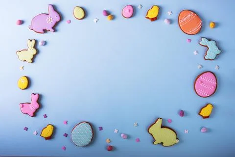 Happy Easter. Multicolored frame pastel easter cookies on a blue background. Stock Photos