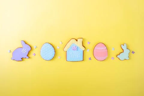 Happy Easter. Multicolored pastel easter cookies on a yellow background, various Stock Photos