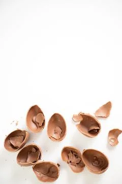 Happy Easter. Open broken destroyed crumbled chocolate eggs on a white Stock Photos