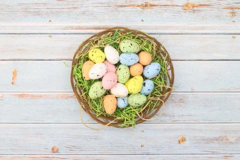 Happy Easter. Pastel colored eggs for Easter in decorated basket Stock Photos