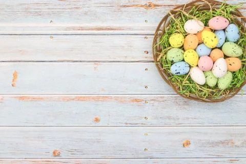 Happy Easter. Pastel colored eggs for Easter in decorated basket Stock Photos
