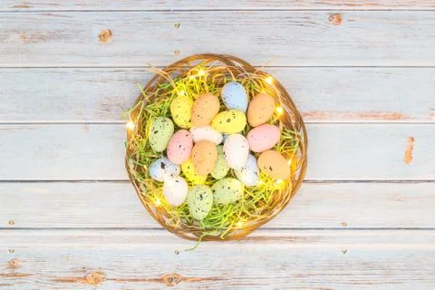 Happy Easter. Pastel colored eggs for Easter in decorated basket Stock Photos