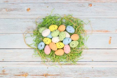 Happy Easter. Pastel colored eggs for Easter in decorated basket Stock Photos