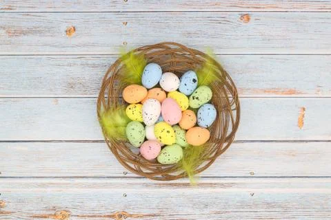 Happy Easter. Pastel colored eggs for Easter in decorated basket Stock Photos