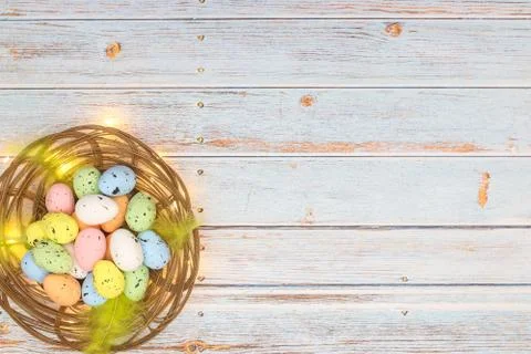 Happy Easter. Pastel colored eggs for Easter in decorated basket Stock Photos